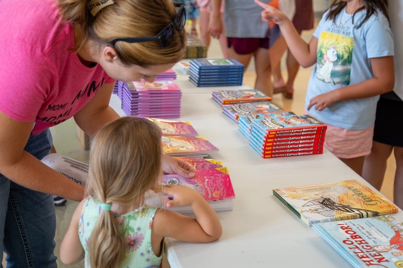 A young girl and her mom looking at a book.